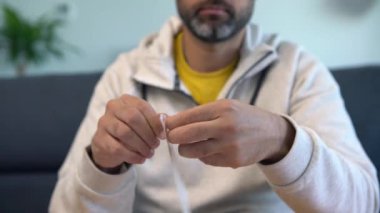 Maske takan beyaz bir adam evde Coperid-19 antijen test cihazının bir örneğini açıyor. Koronavirüsü test etmek için bir kişi antijen test kiti yapar. PCR karantina salgınında.