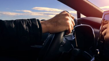 Araba süren bir adam. Tanımlanamayan beyaz sürücü direksiyonda el ele tutuşuyor, yepyeni bir araba kullanıyor.