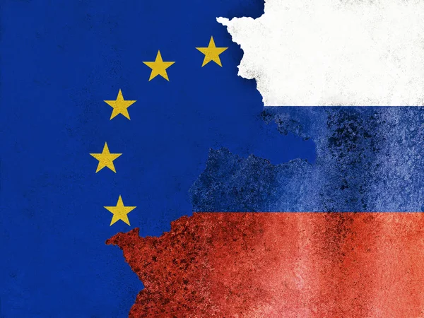 Hasarlı duvar dokusu ve arka plan üzerine Avrupa Birliği ve Rusya bayrakları. Rus kasabasının dışındaki terk edilmiş sanayi binasında uzun taş çatlaklı Avrupa afişi..