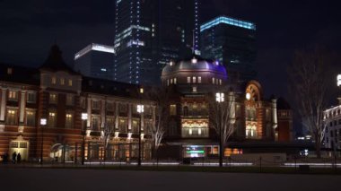 Tokyo istasyonu manzarası geceleri tuğladan yapılmış. Chiyoda 'nın Marunouchi iş bölgesinde ünlü bir demiryolu binası ve gece vakti çevreleyen ofis binaları..
