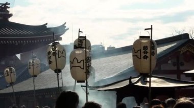 Tokyo, Japonya-03 Şubat 2020: Geleneksel giyinmiş Asyalı erkekler Setsubun, Fasulye fırlatma festivali sırasında Sensoji tapınağının bambu çubuğuna asılmış kağıt fener alıyorlar. Bahar mevsimi için Japon kültürü.