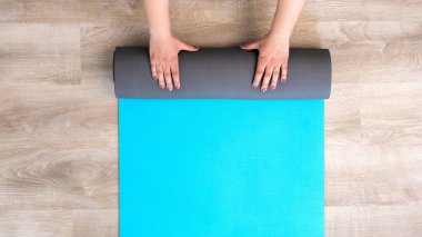 Egzersiz paspasıyla evin içinde yoga sporu eğitimine hazırlanan genç bir kadının en iyi görüntüsü. Meditasyon ve spor egzersizleri evde yapılır..
