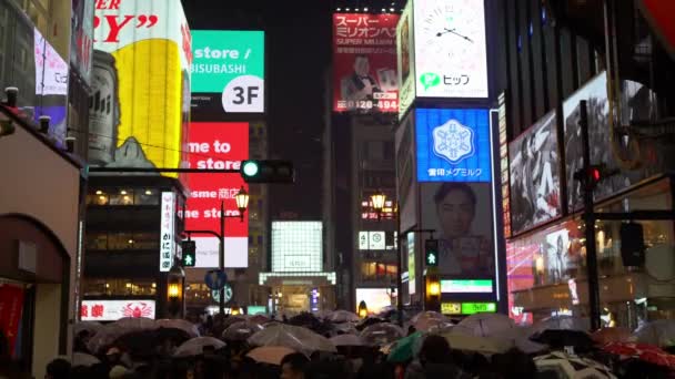 日本大阪 2019年4月14日 游客在雨中行走 雨天晚上在多顿堡的街道上购买带有霓虹灯标志的食品 Dotombori是著名的旅游胜地 — 图库视频影像