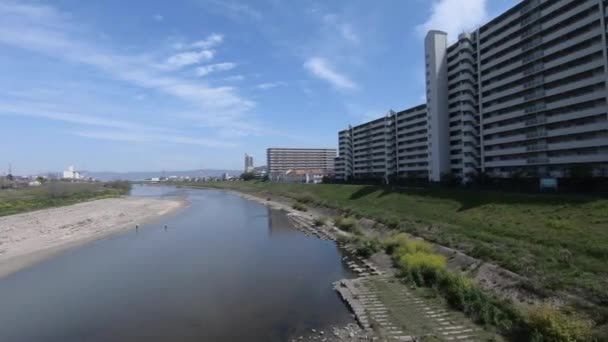 2019年4月16日大阪府大阪市 電車の窓からの都市景観と川の景色は 青空が広がる美しい一日の間に市内を旅します 日本の家の建物と通り 旅行のコンセプト — ストック動画