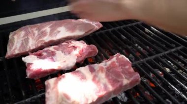 Şef ızgarada domuz pirzolası pişiriyor. İspanya 'da tatil tatillerinde mangalda pişirilmiş leziz domuz ızgarası. Çiğ et