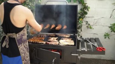 Şef barbekü ızgarası için domuz pirzolasına leziz sos ve sos koydu. İspanya 'da tatil tatillerinde mangalda pişirilmiş leziz domuz eti..