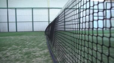 Bir kulübün içindeki yeşil kortta raket tenis ağı hareketi. Raket sporu konsepti