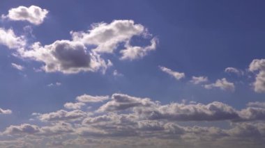 Güneşli bir yaz gününde mavi gökyüzü olan kümülüs bulutları. Doğa arkaplan manzarası olarak güzel bulutlar. Beyaz bulutların yüzdüğü, soyut bir şekil oluşturan doğal gün ışığının harika havası.