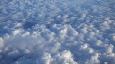 Güzel bulut manzarası. Beyaz bulutların üzerindeki panorama bir uçağın penceresinden görülebiliyor. Uçaktan manzara