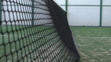 Bir kulübün içindeki yeşil kortta yavaş hareket eden raket tenis ağı. Raket sporu konsepti