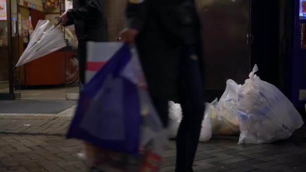 2019年4月14日大阪 道頓堀を背景に飲食店が立ち並ぶ歩道上のゴミ 夜の街のゴミ 分別収集のための透明なゴミ袋 — ストック動画