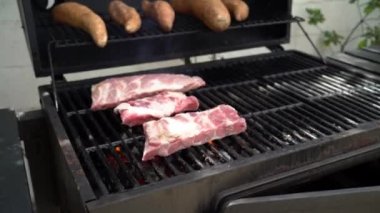 Şef ızgarada domuz pirzolası pişiriyor. İspanya 'da tatil tatillerinde mangalda pişirilmiş leziz domuz ızgarası. Çiğ et