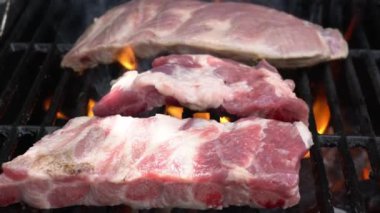 Barbekü ızgarasının üzerinde lezzetli bir domuz pirzolası pişirmenin yavaşlığı. Izgarada domuz eti pişir. Evin arka bahçesinde ızgarayla pişirilen yemekler.