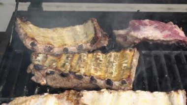 Barbekü ızgarasında domuz pirzolası pişiren şefin yavaşlaması. İspanya 'da tatil tatillerinde mangalda pişirilmiş leziz domuz eti..