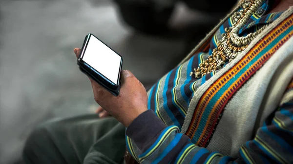 Mockup of smartphone and an aboriginal dressed traditional clothes of tribe in Formosan village. Taiwanese indigenous man holding phone device with mock up ready for your design preview. Mock-up