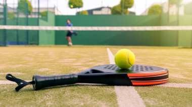 Beyaz, olgun bir adam ağların arkasında Padel raket ve sarı topla oynuyor. Gün batımında yeşil çimlerin üzerinde. Kürek bir raket oyunudur. Metin için alanı olan profesyonel spor kavramı