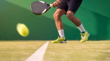 Dış sahada kürek sporu pratiği yapan bir monitör. Öğrencisine padel dersi veren bir adam. Profesyonel insanlar nasıl paddel oynanacağını öğretir. Bir spor oyunu konsepti öğren.