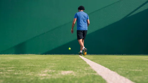 A caucasian padel player jump to the ball, good looking for posts and poster. Man with black racket playing a match in the open behind the net court outdoors. Paddle is a racquet game. Racquet game