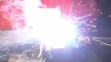 Close up of skillful metal worker working with arc welding machine in factory while wearing safety equipment. Metalwork manufacturing and construction maintenance service by manual skill labor concept