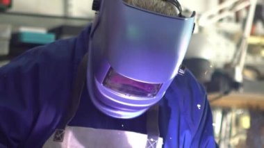 Slowmotion of skillful metal worker working with arc welding machine while wearing safety equipment. Metalwork manufacturing and construction maintenance service by manual skill labor concept.