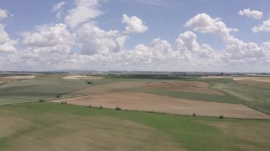 Aerial panoramic view of empty paved road through the fields during sunny day. Top view from drone of asphalt way at countryside. Rural scene in Spain. Traffic ways transportation logistics concept.