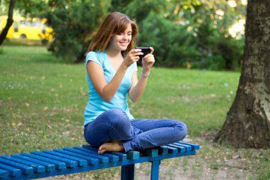 telefon ile parkta güzel bir kız