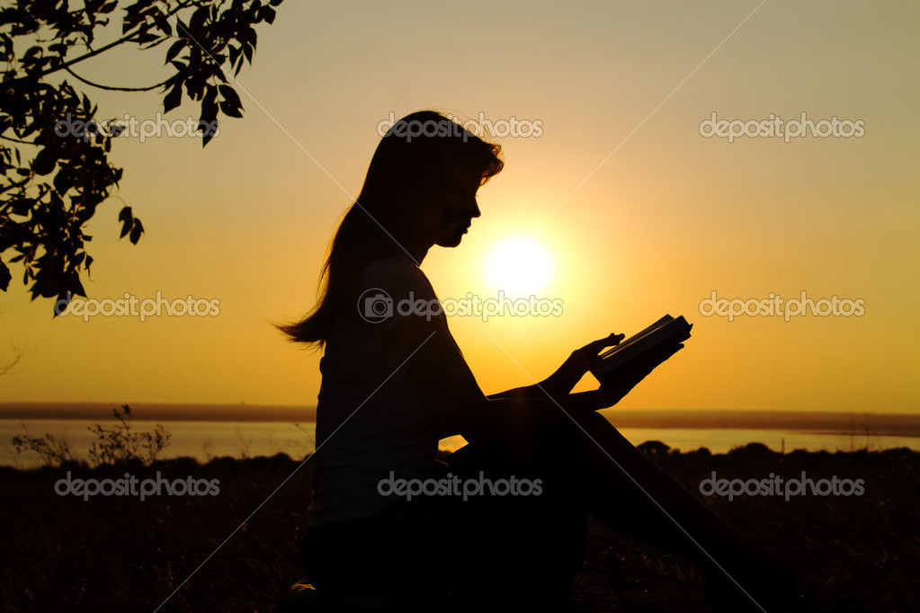 Silhouette of a girl reading at sunset — Stock Photo © fantom_rd 30220955