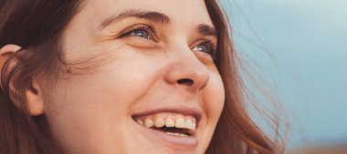 Mutlu kızıl saçlı genç bir annenin portresi çimlerin üzerinde yürüyor, kadının duygu yaşam konseptini kapatıyor.