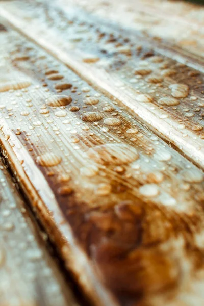 雨に濡れた木の板から光沢のある水が落ちる漆塗りの木の質感の背景 — ストック写真
