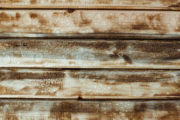 Yağmurdan parlak su damlaları, ıslak ahşap kalaslar, üst manzara.