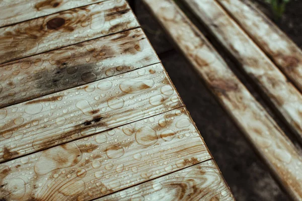 ベンチやテーブルのぬれた木の板雨の上からの水の滴と木の質感の背景 — ストック写真