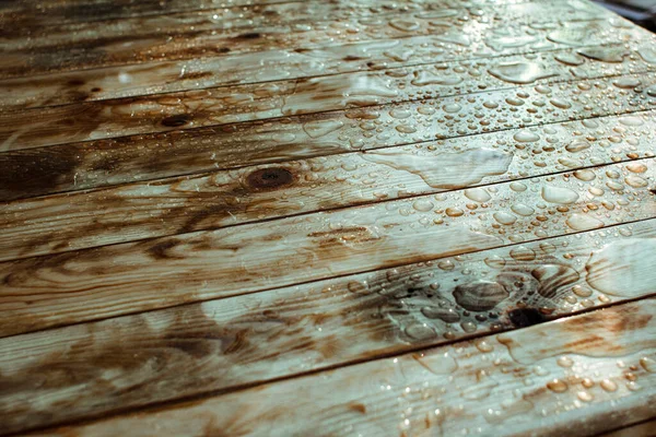 光沢のある水滴や雨からの水たまり 湿った木製の板と漆塗りの木の質感の背景 — ストック写真