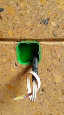 Elektrik kablosu, duvardaki bir olukta koruyucu bir şekilde yerleştirilmiş. İnşaat halindeki bir evde elektriğe hazırlanmak için duvardaki deliklere elektrik kabloları yerleştirmek..