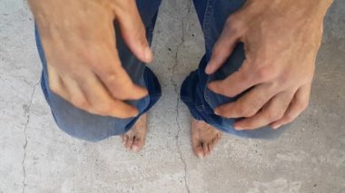 Betonda kirli ve çıplak ayaklar. Huzursuz ve sinirli bir insanın elleri ve ayakları. Evsiz ve başıboş bir insan. Yoksulluk kavramı. Stres ve depresyon. Umutsuz bir durum..
