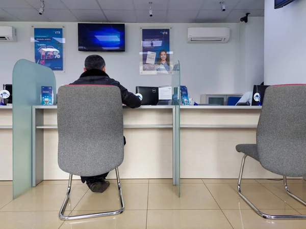 Erevan, Ermenistan - 22 Mart 2022. Bankadaki insanlar bir banka çalışanıyla mali işlemler yapıyorlar. Banka bekleme odası. Finansal hesaplamalar. Banka faaliyetleri.