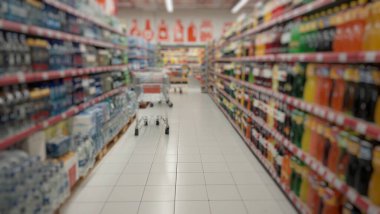Süpermarketteki malların bulanık odaklı arka planı. Ürünlerle dolu raflar. Yiyecek ürünleri. Yemek masrafları. Süpermarketin iç kısmının arka planı.
