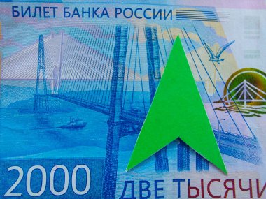 Rublonun yüksek değerli konsepti. Rus bankasının iki bininci banknotunun bir parçası. Üst tarafı işaret eden yeşil ok. Rublonun değerini artırmak için. Rus para biriminin büyümesi