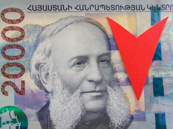Ermeni dramının düşüşü konsepti. 20 bin sterlin değerindeki bir banknotun parçası. Kırmızı ok aşağı işaret ediyor. Makro fotoğrafçılık. Ermenistan para biriminin parasal dolaşımı.
