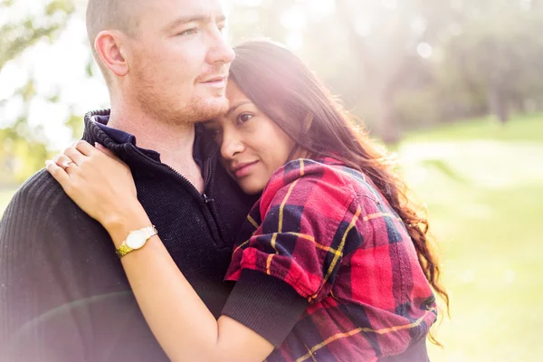 Romántico joven pareja retrato, mujer asiática, hombre caucásico, abrazos tiernamente en el ambiente al aire libre y hermosa luz — Foto de Stock