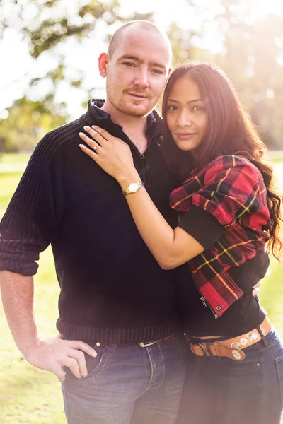 Romântico jovem casal retrato, mulher asiática, homem caucasiano, abraçando ternamente no ambiente ao ar livre e bela luz — Fotografia de Stock