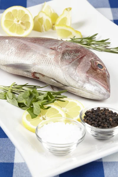 A red sea bream with spices, lemon slices and herbals — Stock Photo, Image