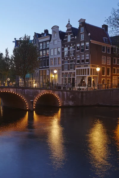 Amsterdam, Nederland - huizen aan een gracht in het blauwe uur — Stockfoto