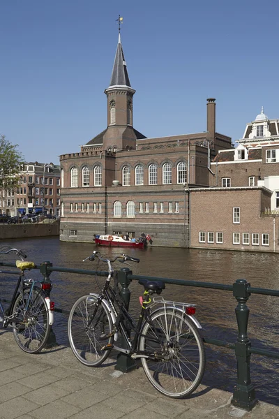 Amsterdam, Paesi Bassi - Antico edificio con torre su un canale — Foto Stock