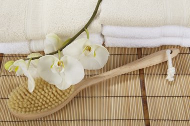 Bir bambu mat, havlu ve bir orkide banyo fırçası