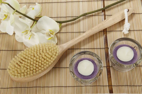Bath brush, orchid and tealights on a mat of bamboo — Stock Photo, Image