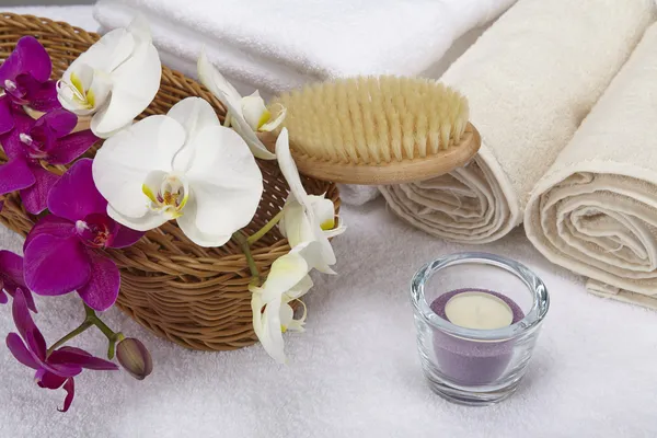 Badkar pensel, rullade handdukar, värmeljus och orkidéer — Stockfoto