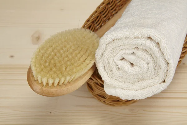 Bath brush and rolled towel in a basket — Stock Photo, Image