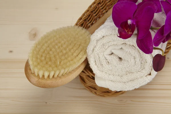 Bath brush and rolled towel in a basket — Stock Photo, Image