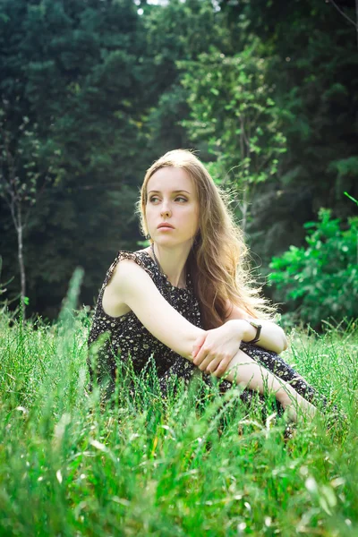 Woman sits at a forest's meadow — Stock Photo, Image