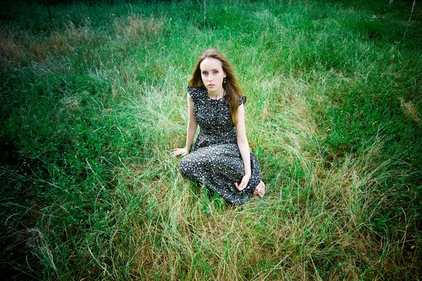 Woman sits at a meadow — Stock Photo, Image